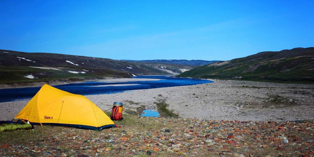 a yellow tent next to a river