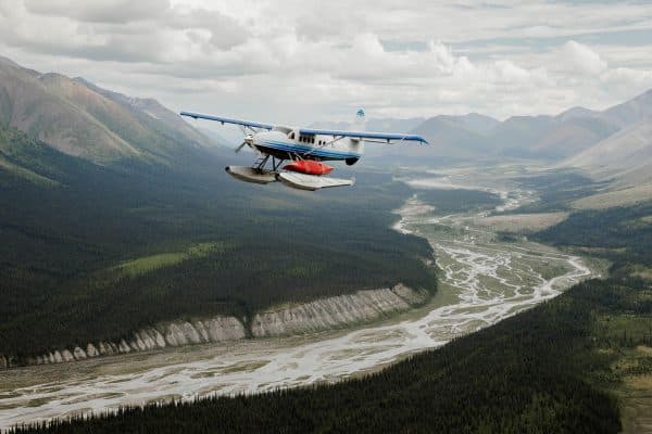 Seaplane flying over mountainous landscape.