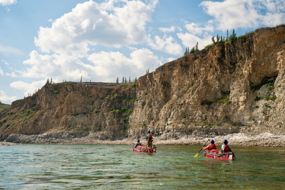 Canoeing amidst towering limestone cliffs along the Horton River.
