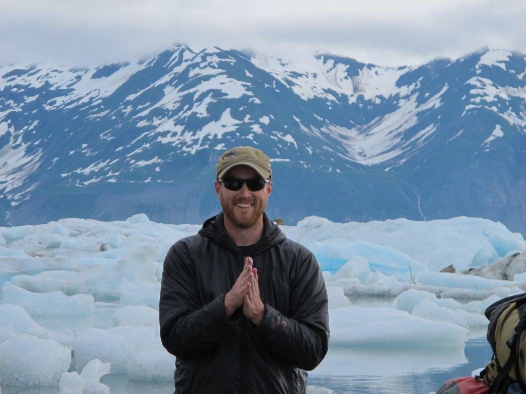 a man standing in front of a snowy mountain
