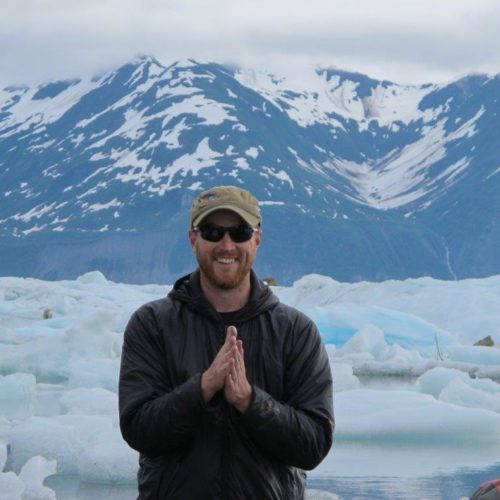 a man standing in front of a snowy mountain