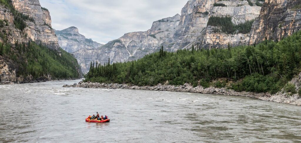 a rafting on a river with trees and mountains