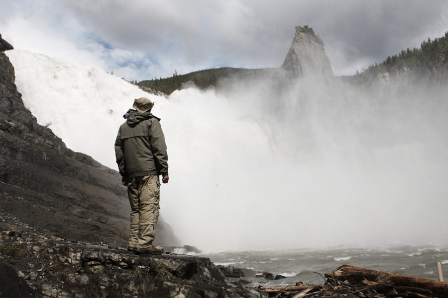 Standing below the thundering Virginia Falls on the Nahanni River in Nahanni National Park Preserve.