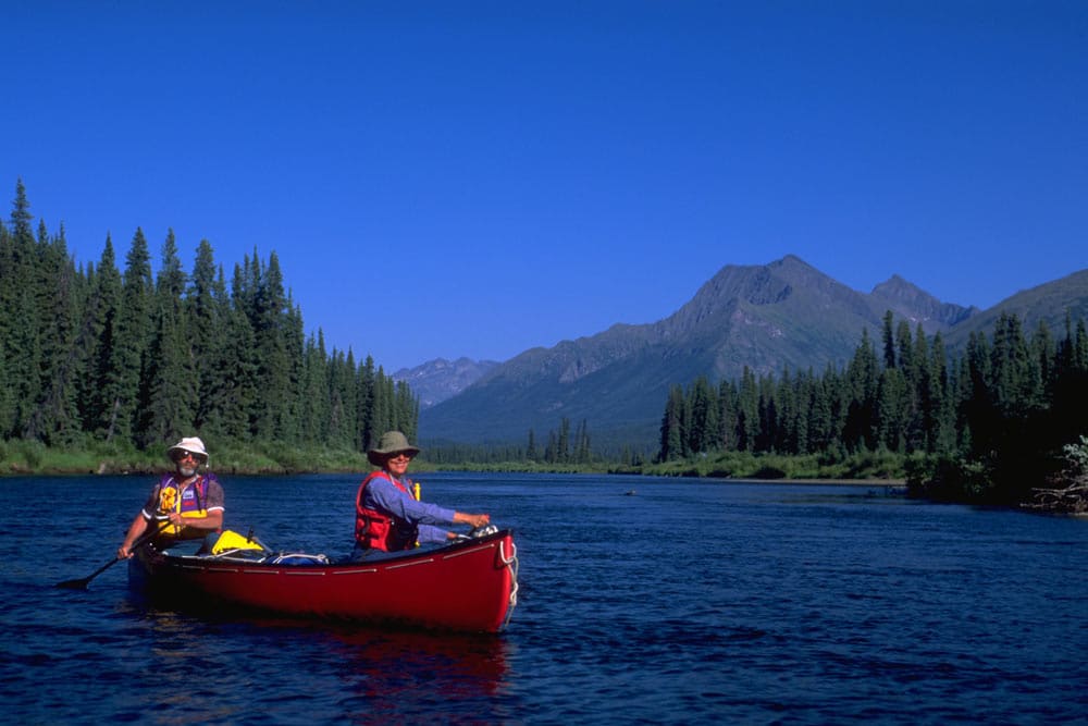 a couple of people in a canoe on a lake