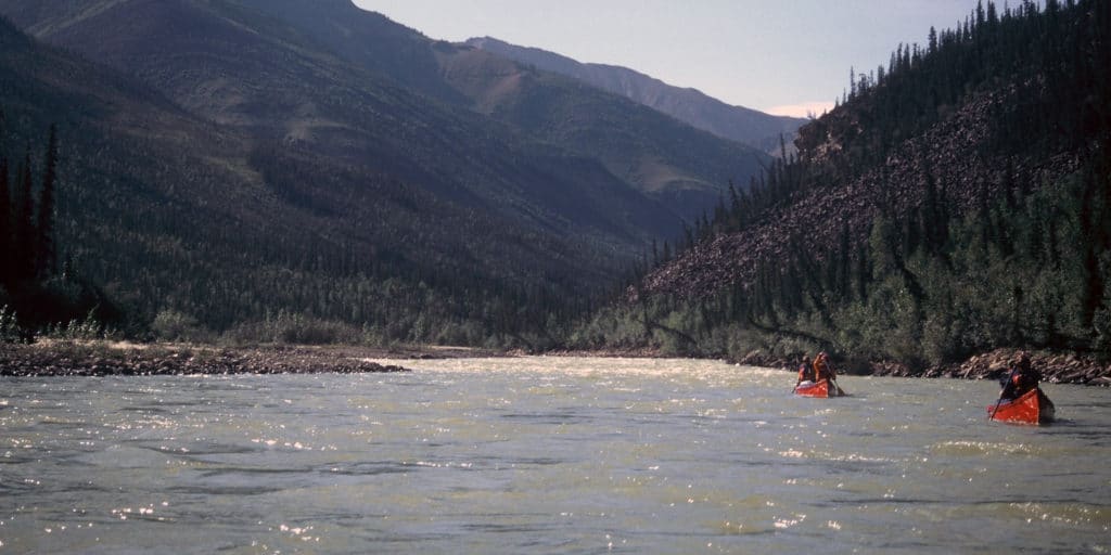 a group of people in a canoe on a river