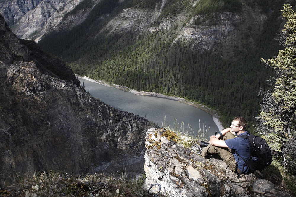 Hiker perched high above the Nahanni River in Nahanni National Park Preserve in Canada's Northwest Territories.