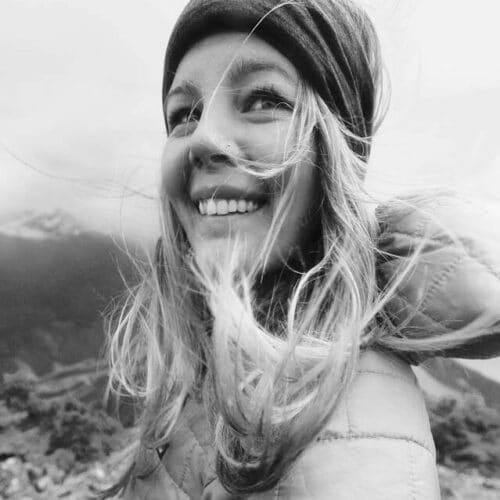a woman smiling with her hair blowing in the wind