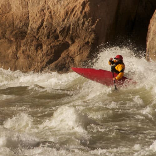 a person in a red kayak in the water