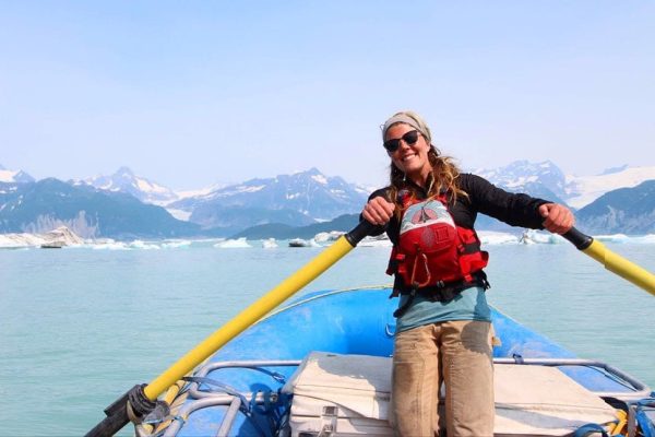 a woman on a boat with a yellow oar