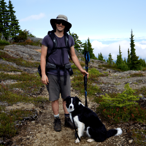 a man with a dog on a rocky trail