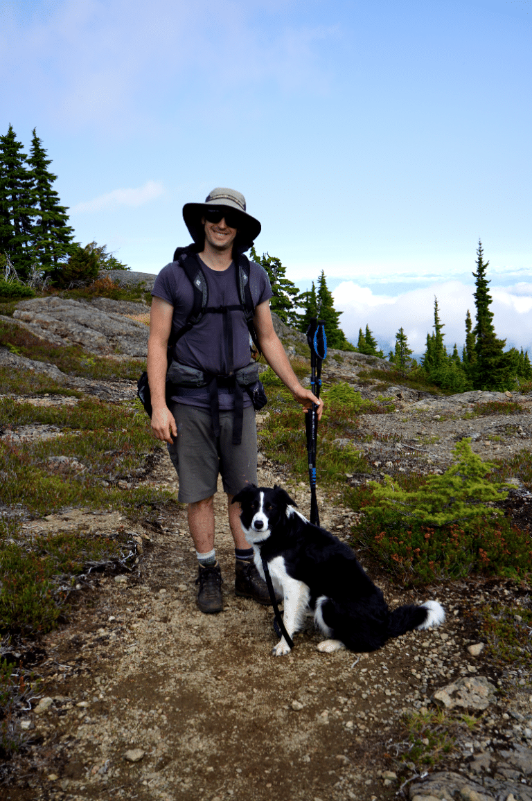 a man with a dog on a rocky trail