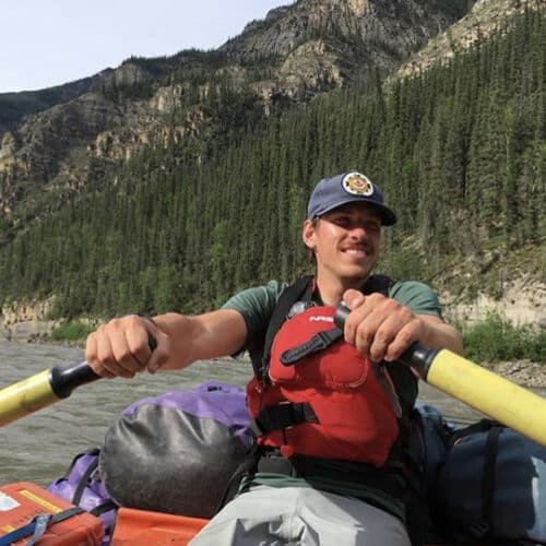 a man in a boat with paddles