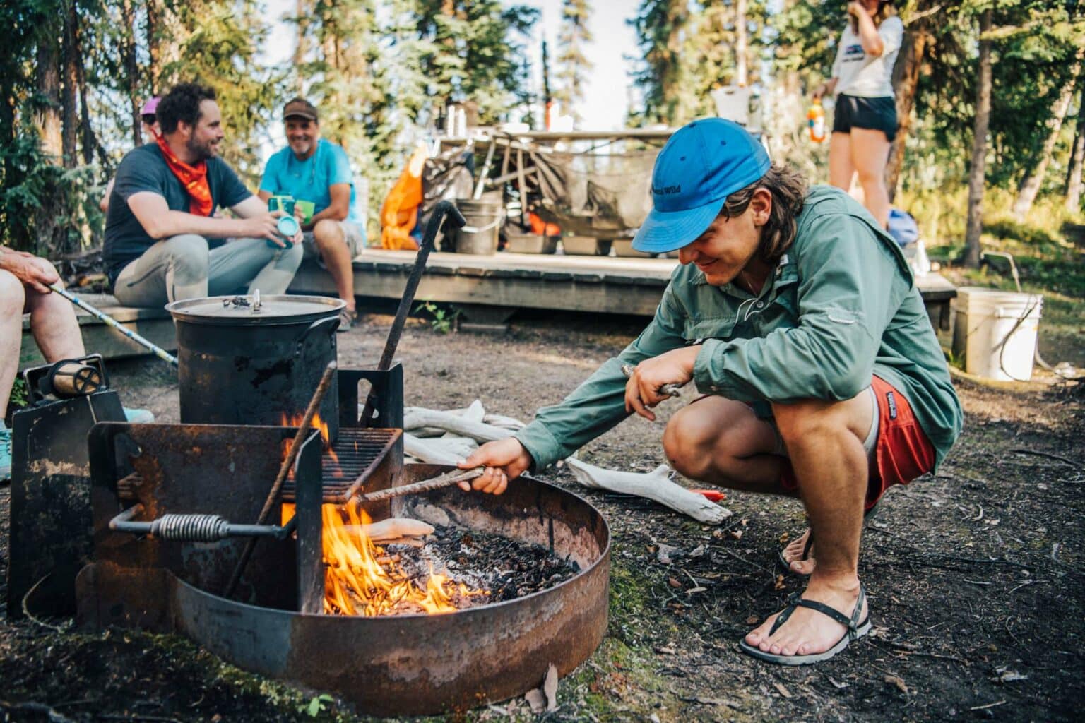 a man in a blue hat lighting a fire