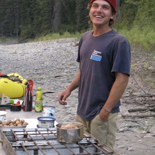 a man standing next to a table with food