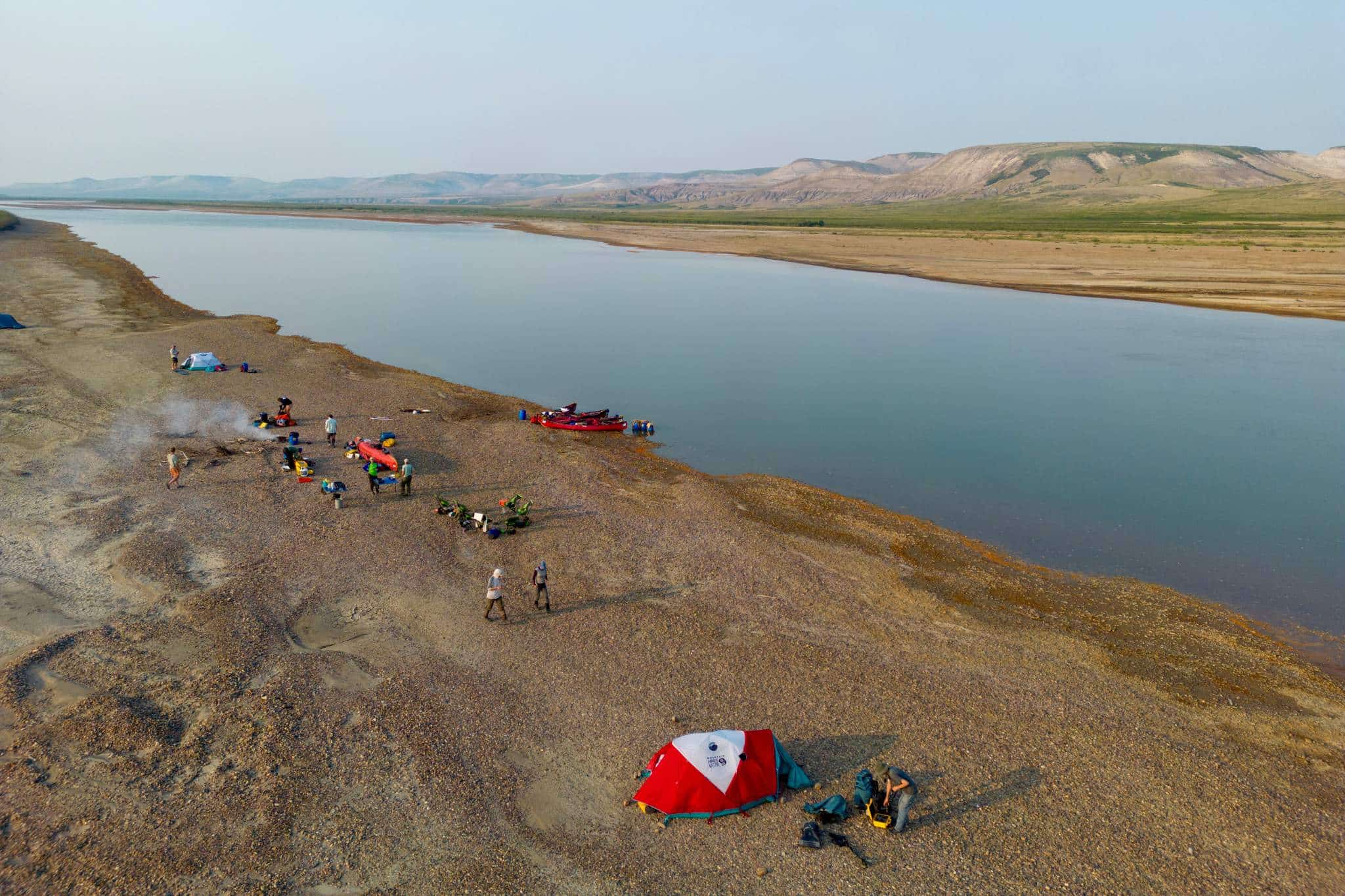 a group of people camping on a rocky beach
