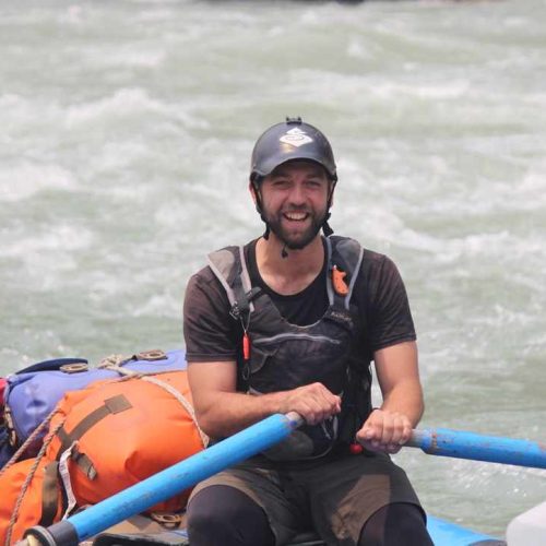 a man in a boat with a blue pole