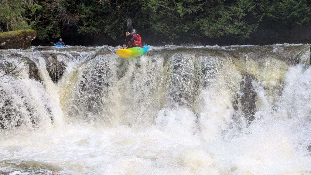 a man in a kayak on a waterfall