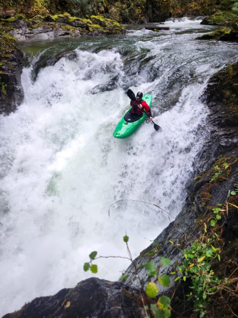 a person in a kayak on a waterfall