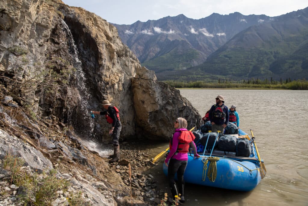 a group of people in a raft next to a body of water