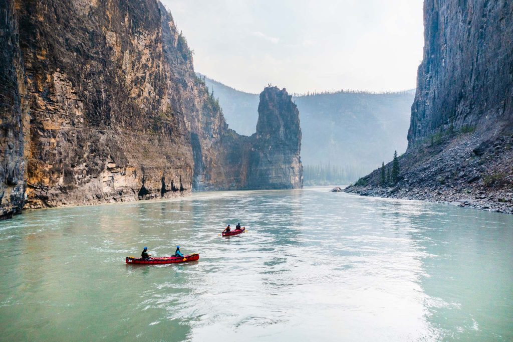 Kayakers navigating a serene canyon river.