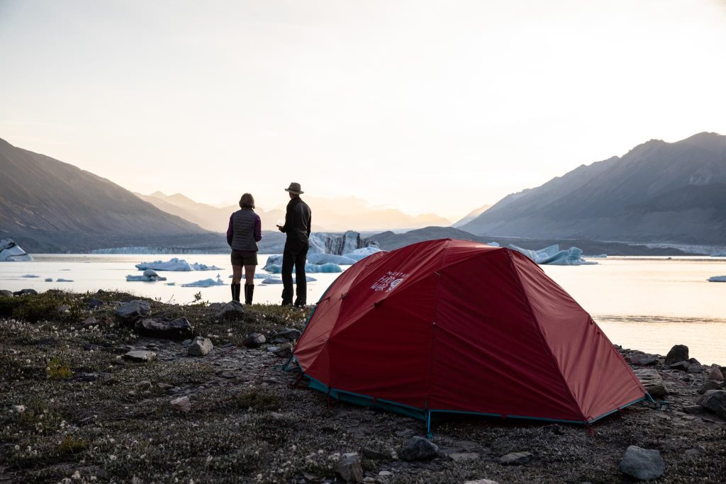 Couple by tent near glacier lake