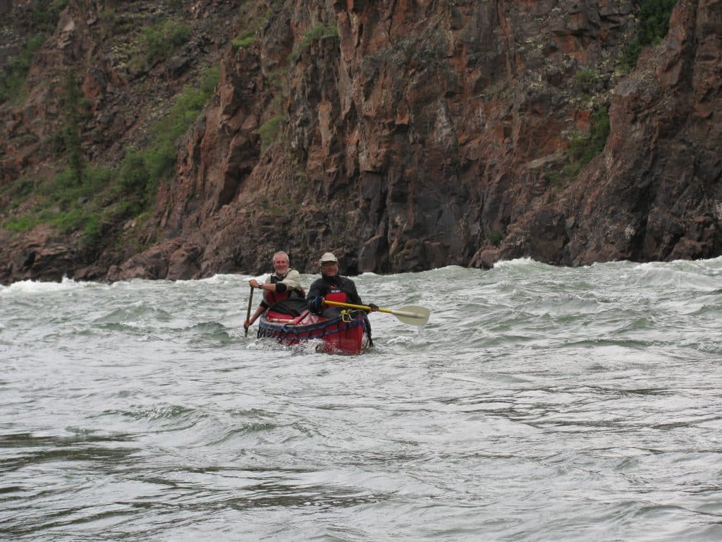 Two people kayaking on rough water