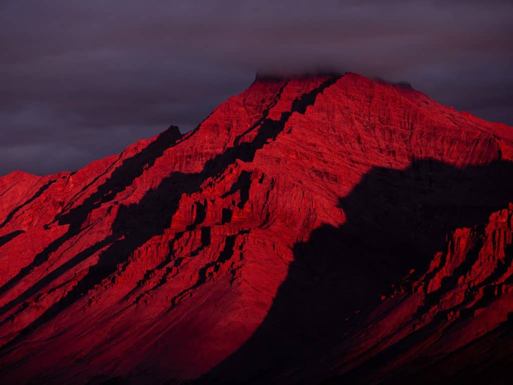 Red mountain under dramatic clouds
