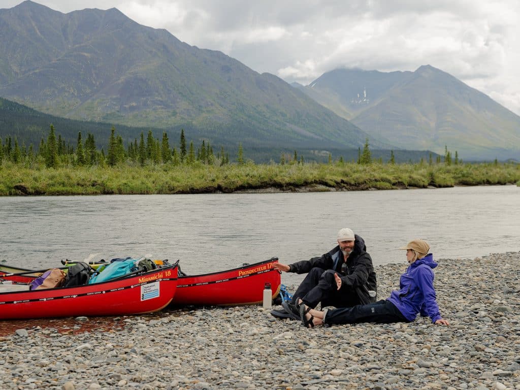 Two people relaxing by riverbank