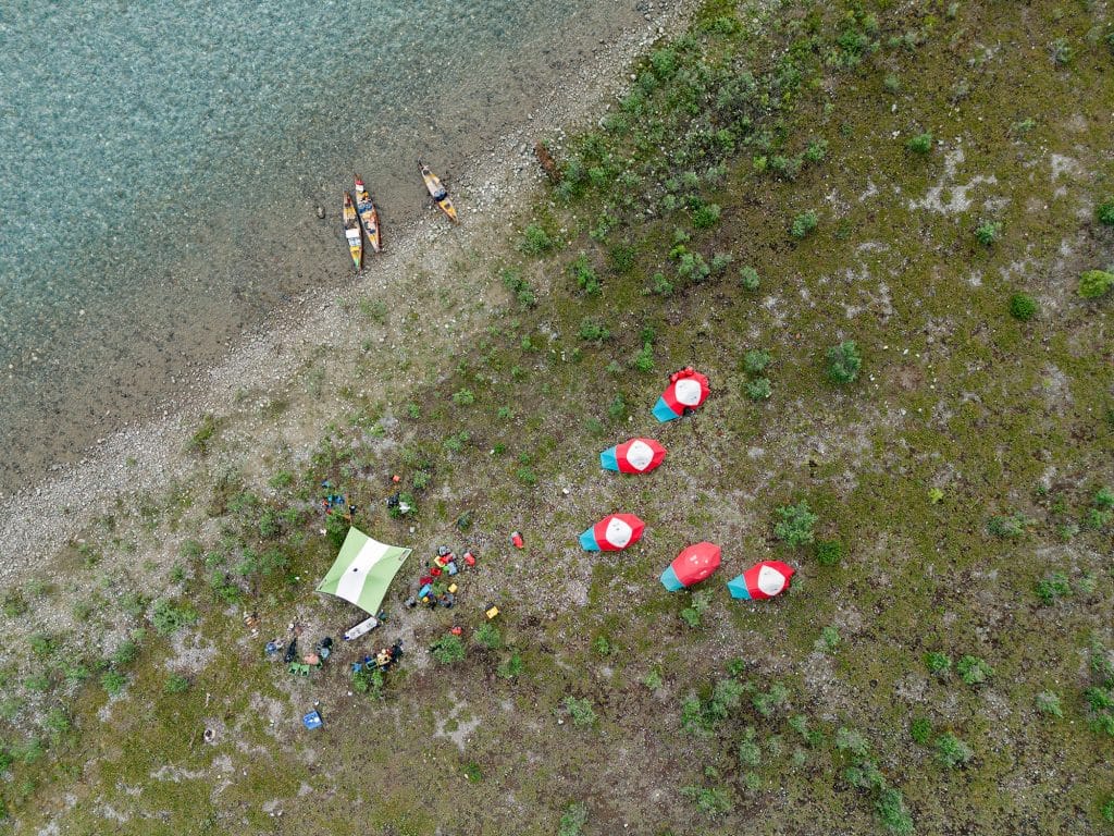 Kayakers near tents by water