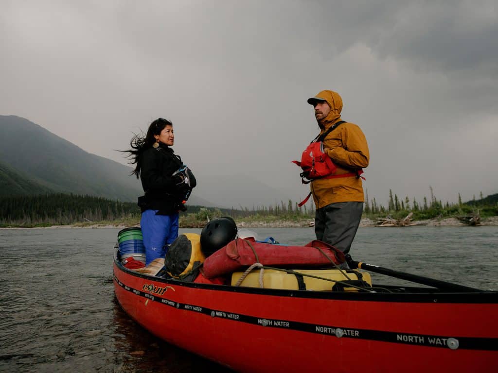 Two people in canoe on river.