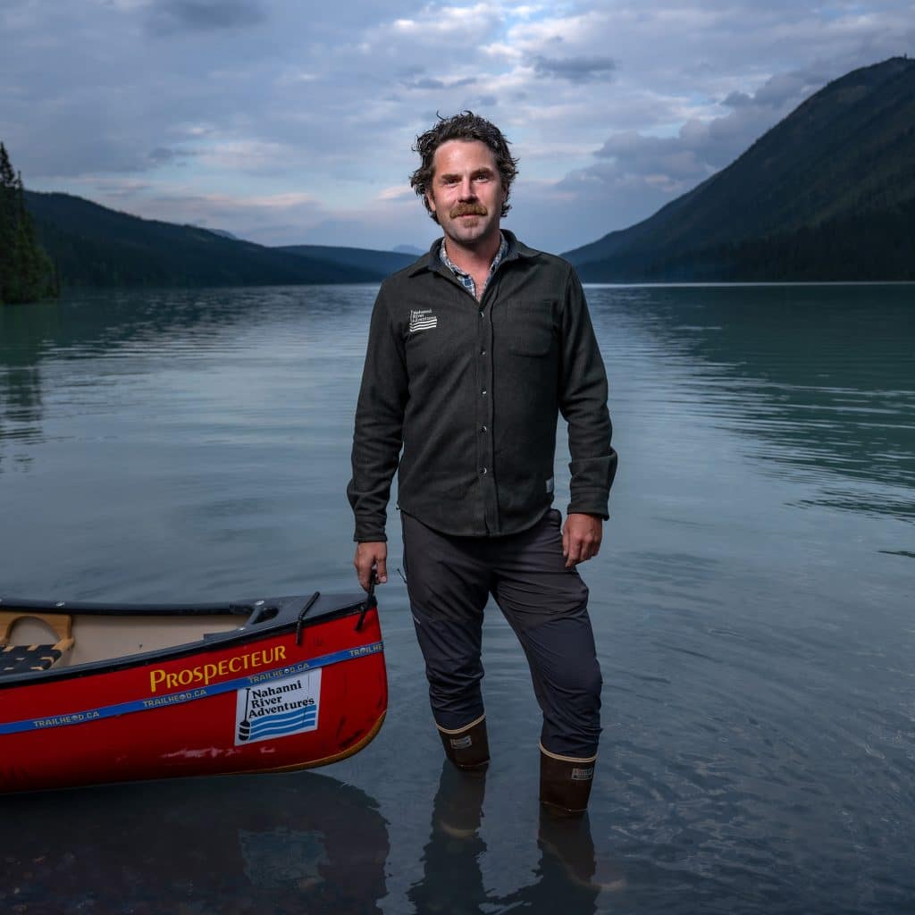 Man standing by canoe in water